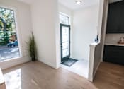 Thumbnail 35 of 44 - A room with a black door and a plant in it.