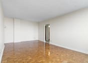 Thumbnail 21 of 21 - A room with a wooden floor and a door on the right side.