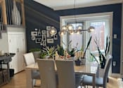 Thumbnail 13 of 15 - A dining room with a table and chairs.