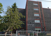 Thumbnail 1 of 5 - A brick building with a sign that says Sacred Heart Manor.