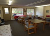 Thumbnail 3 of 5 - A room with tables and chairs and a window.