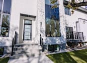 Thumbnail 29 of 44 - A modern house with a white exterior and large windows.