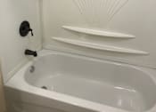 Thumbnail 9 of 9 - a white bathtub with white walls and black fixtures
