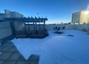 Thumbnail 2 of 9 - A snow-covered rooftop with a table and chairs.