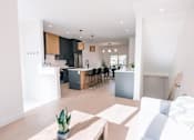 Thumbnail 16 of 44 - A modern kitchen with a dining area and a living room.