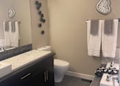 Thumbnail 8 of 15 - A bathroom with a toilet, sink, and mirror.
