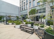 Thumbnail 16 of 26 - a courtyard with benches and plants in front of a building