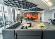 Thumbnail 15 of 26 - a living room with couches and tables and a dining room in the background