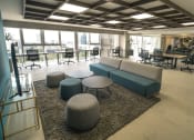 Thumbnail 15 of 31 - a lounge area with blue couches and chairs and a rug