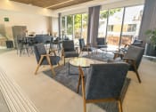 Thumbnail 7 of 31 - a lounge area with chairs and tables and a large window