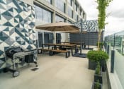 Thumbnail 5 of 31 - a rooftop patio with tables and umbrellas and a grill