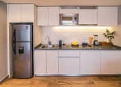 Thumbnail 22 of 26 - a kitchen with white cabinets and a stainless steel refrigerator