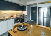 Thumbnail 18 of 31 - a kitchen and dining room with a wooden table and a stainless steel refrigerator