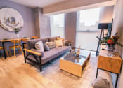 Thumbnail 10 of 26 - a living room with a couch and a table and a large window