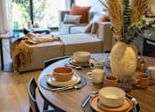 Thumbnail 4 of 7 - A table set for a meal with a vase of dried flowers in the center.