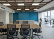 Thumbnail 13 of 31 - a conference room with a wooden table and chairs and a blue wall
