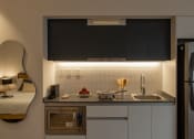 Thumbnail 24 of 31 - a small kitchen with a sink and a refrigerator
