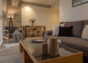 Thumbnail 19 of 31 - a living room and dining room with a couch and a table