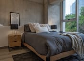 Thumbnail 17 of 31 - a bedroom with a bed and a large window