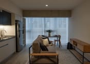 Thumbnail 25 of 31 - a living room with a couch and a table in front of a window
