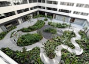 Thumbnail 7 of 7 - A courtyard with a circular garden and a winding path.