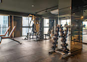 Thumbnail 2 of 12 - A gym with a variety of equipment including a leg press machine.