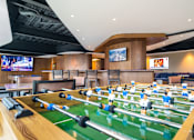 Thumbnail 2 of 12 - a game room with foosball tables and televisions