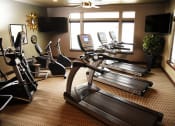 Thumbnail 18 of 53 - a gym with treadmills and televisions