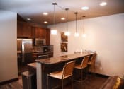 Thumbnail 32 of 53 - a kitchen with a bar and a stainless steel refrigerator
