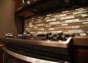 Thumbnail 42 of 53 - a kitchen with a stove top oven and a tile backsplash