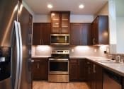 Thumbnail 34 of 53 - a kitchen with stainless steel appliances and wooden cabinets