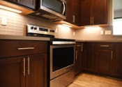 Thumbnail 38 of 53 - a kitchen with stainless steel appliances and wooden cabinets