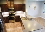Thumbnail 33 of 53 - a large kitchen with stainless steel appliances and wooden floors