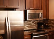 Thumbnail 53 of 53 - a kitchen with stainless steel appliances and wooden cabinets