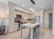 Thumbnail 16 of 59 - a kitchen with white cabinets and a white island with three stools