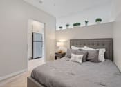 Thumbnail 17 of 59 - a bedroom with a large bed and a refrigerator in the background
