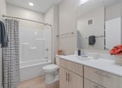 Thumbnail 58 of 59 - a bathroom with a white sink and toilet next to a white bathtub with a shower curtain
