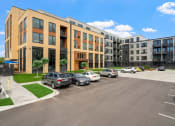 Thumbnail 22 of 59 - a large brick building with a parking lot in front of it