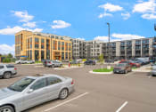 Thumbnail 20 of 59 - a parking lot with cars in front of a building