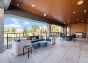 Thumbnail 29 of 59 - a patio with couches and chairs and a grill