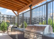 Thumbnail 33 of 59 - an outdoor kitchen with stainless steel appliances and a wooden roof