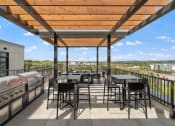 Thumbnail 45 of 59 - a patio with tables and chairs and a grill