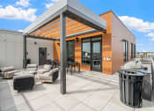 Thumbnail 46 of 59 - a covered patio with a grill and couches