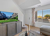 Thumbnail 16 of 63 - a living room with a tv and a view of a mountain