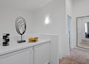 Thumbnail 26 of 63 - a living room with white walls and a white counter top and a mirror