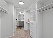 Thumbnail 4 of 63 - a walk in closet with white cabinets and a bathroom with a toilet and a sink