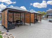 Thumbnail 51 of 63 - a large patio with tables and chairs and a wooden privacy wall