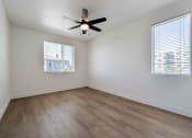 Thumbnail 16 of 49 - an empty living room with wood floors and a ceiling fan
