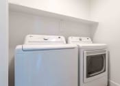 Thumbnail 19 of 49 - a washer and dryer in a laundry room with white walls