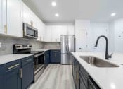 Thumbnail 20 of 49 - a kitchen with blue and white cabinets and stainless steel appliances